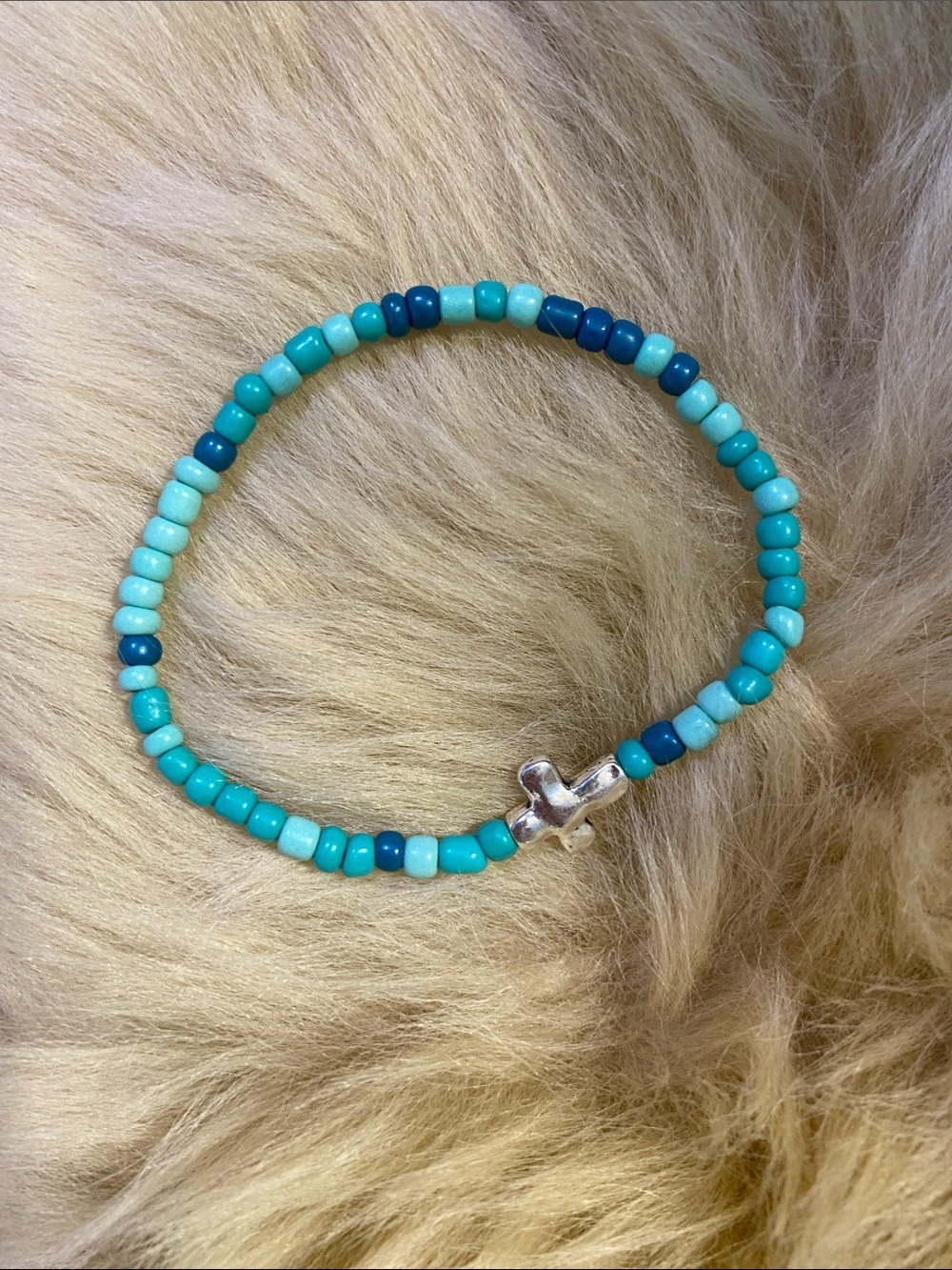 Turquoise colored Beaded Stretch Bracelet with Silver Cross Accent
